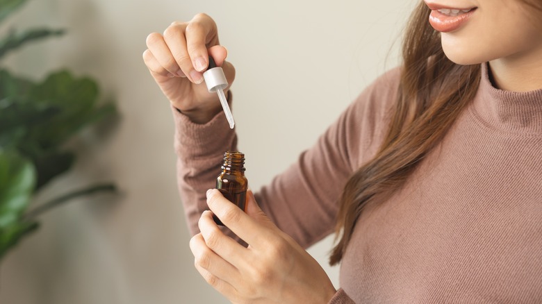 Woman holding essential oil bottle