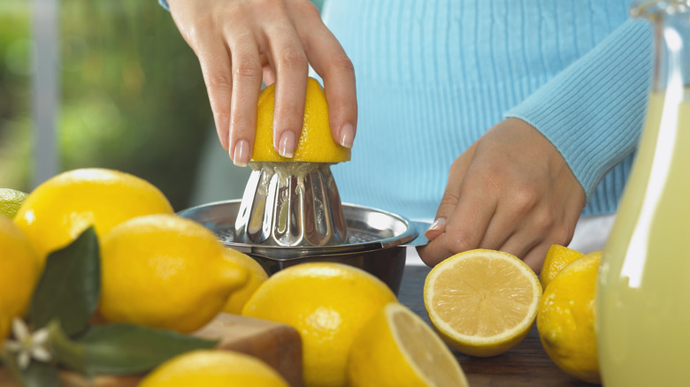 person using lemons on a juicer