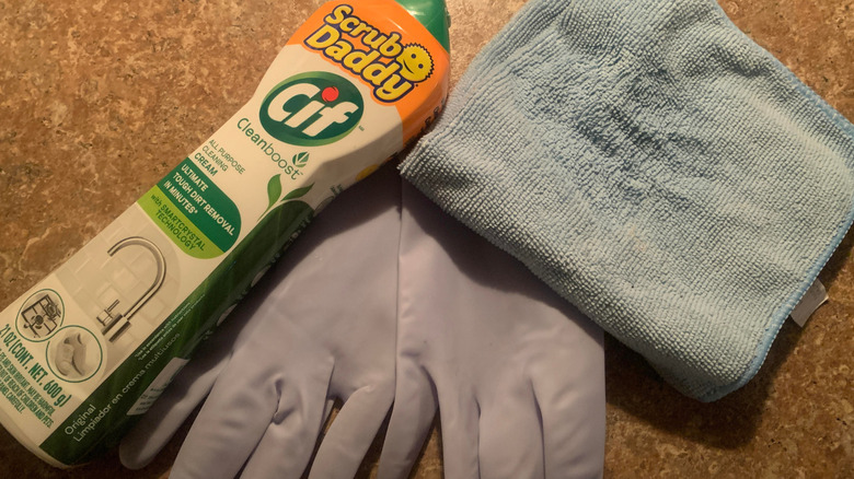 Cif Cream Cleaner, cloth, and cleaning gloves on counter