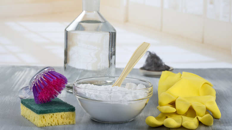 making mold spray with vinegar, baking soda, gloves, and brush