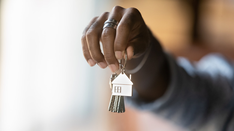 person holding house keychain