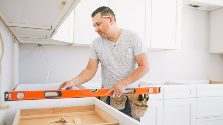 man measuring countertop