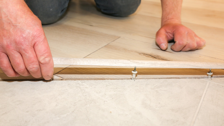 man installing floor threshold