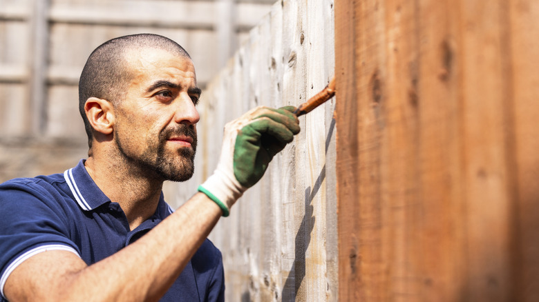 man painting a fence