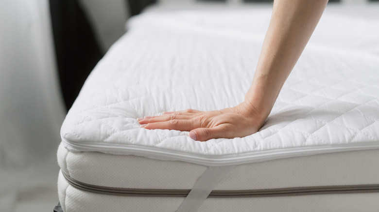 Hand presses on memory foam mattress