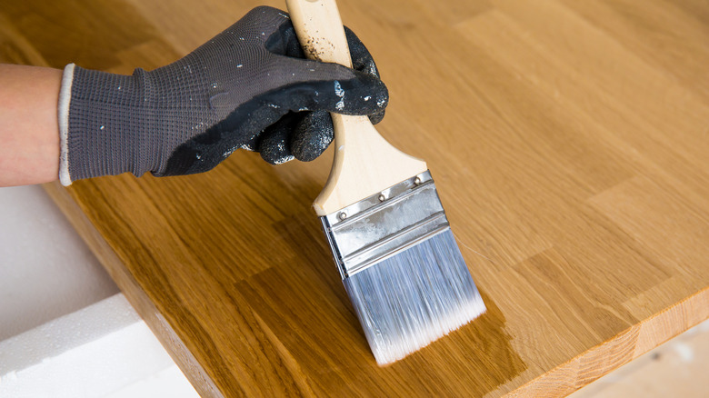 Person applying oil to counters