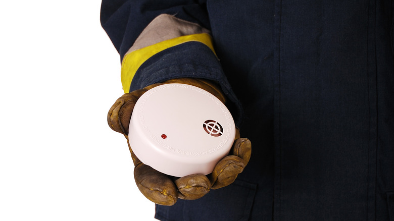 Firefighter holding a smoke alarm