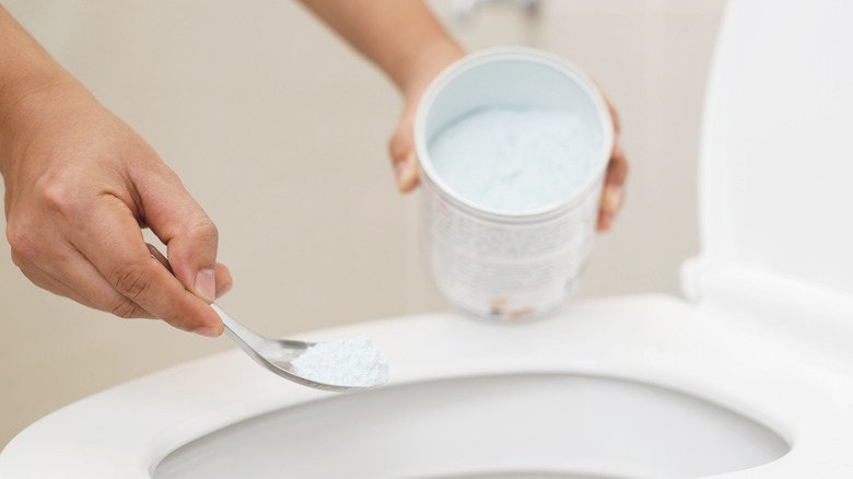 pouring powder on toilet bowl