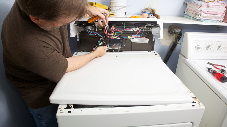 man fixing a dryer 