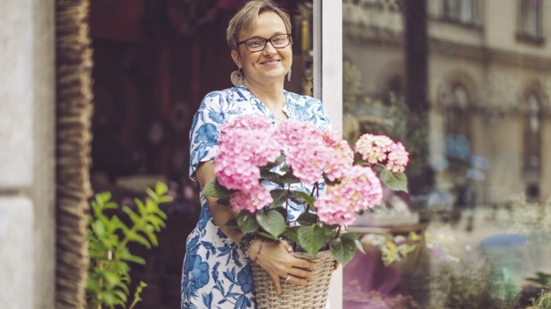 Woman bringing hydrangeas outside 