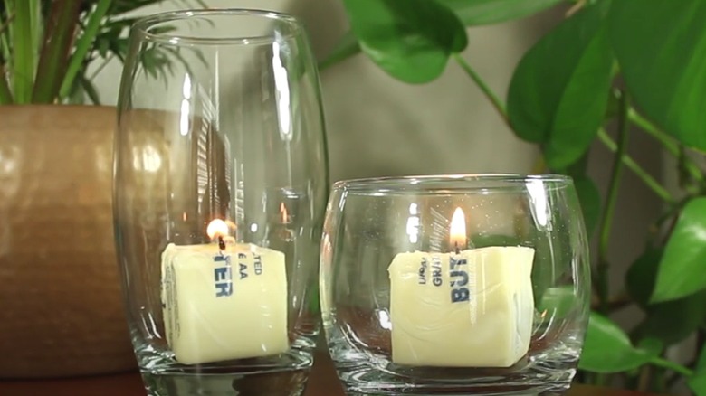 Two glasses with butter candles in them