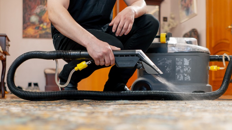 Holding carpet cleaner on floor