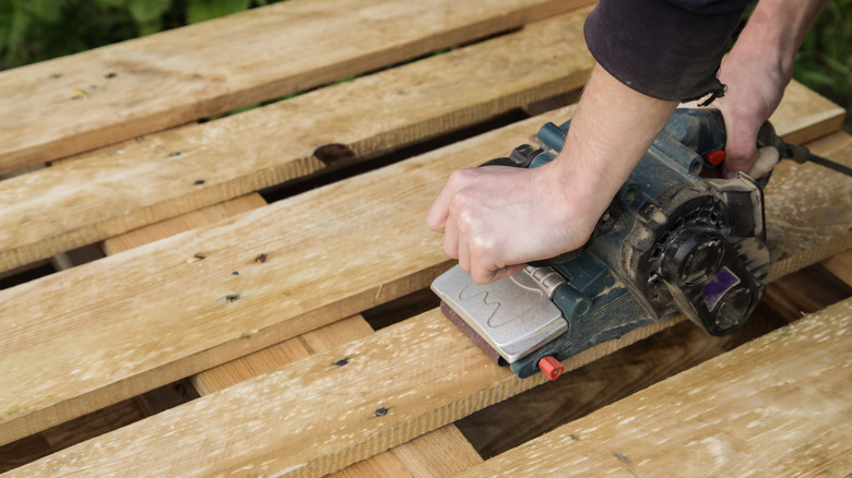 Person using planer on pallet