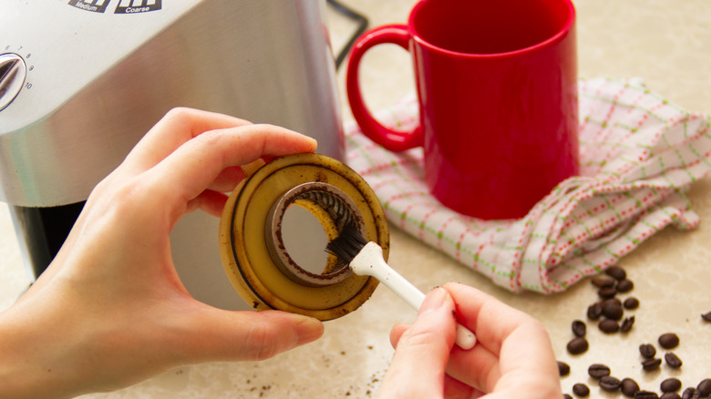 Person cleaning a coffee grinder 