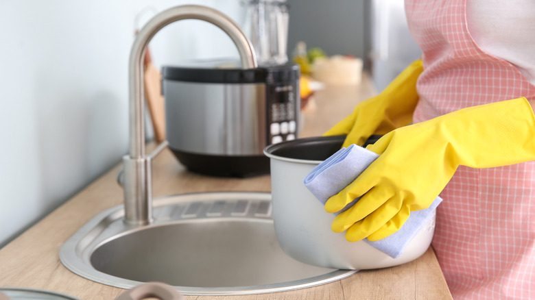 Person washing a slow cooker