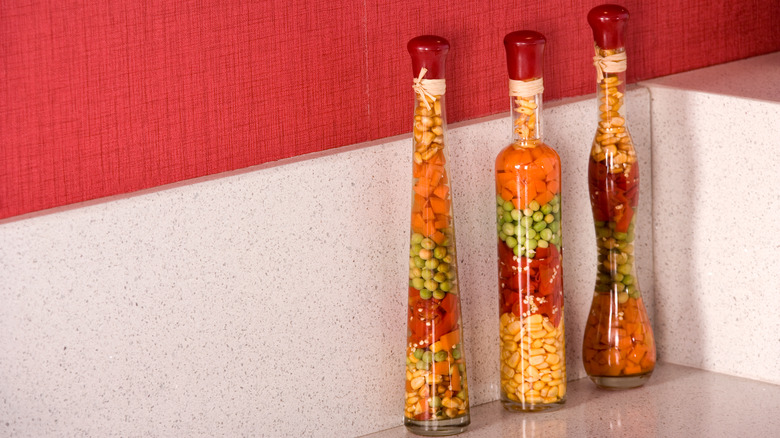 Three decorative bottles of preserves