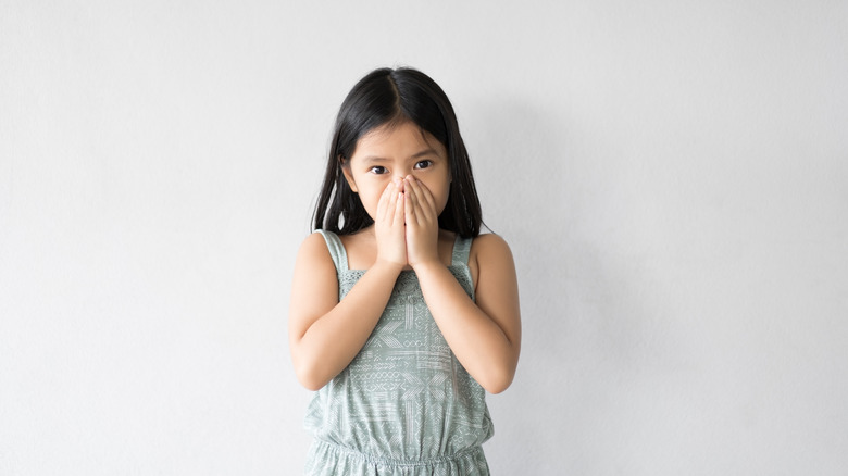 girl covering nose and mouth