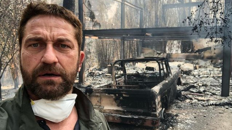 Gerard Butler in front of his burned home 