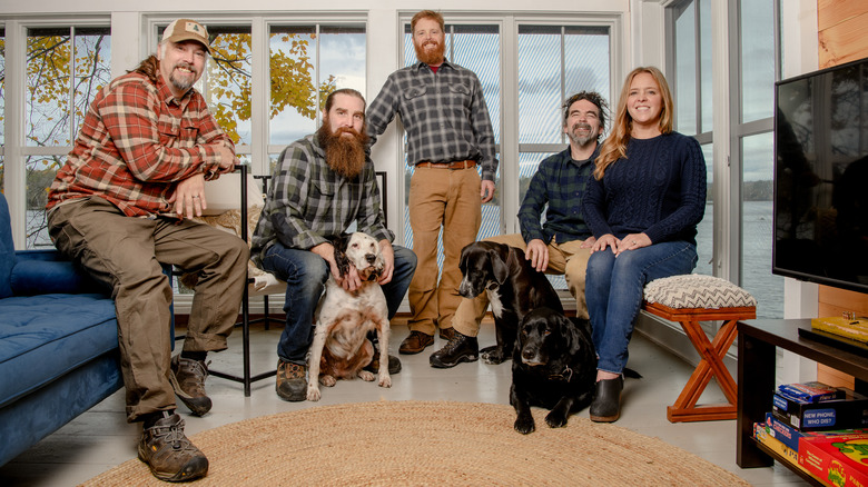 Maine Cabin Masters stars posing inside with dogs