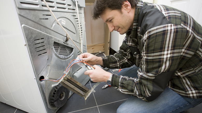 Man fixing dryer heating element