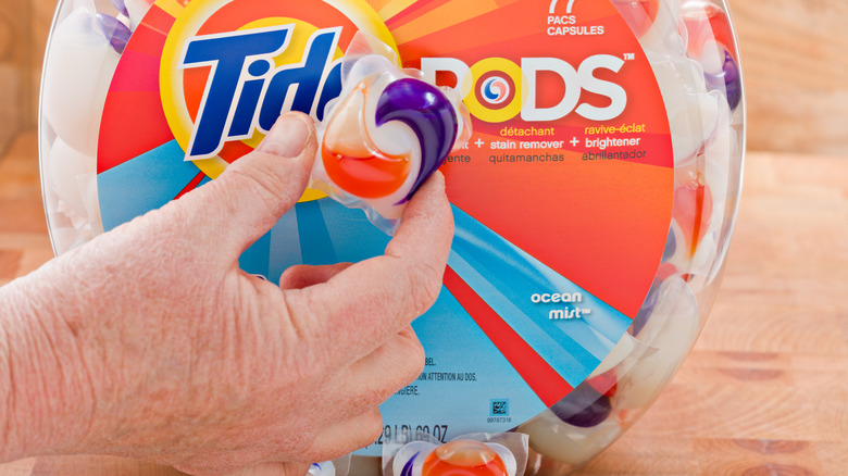 Tide pod held in front of container