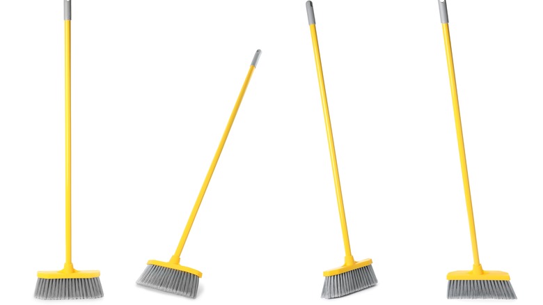 four long-handled brooms