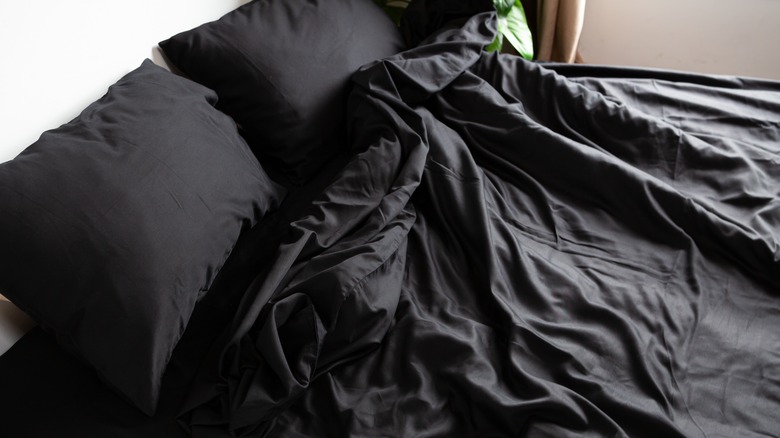 Black sheets on a bed