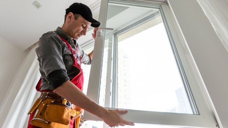 man replacing kitchen window