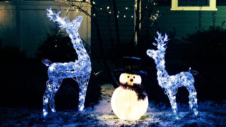 Pre-lit reindeer and snowman in yard
