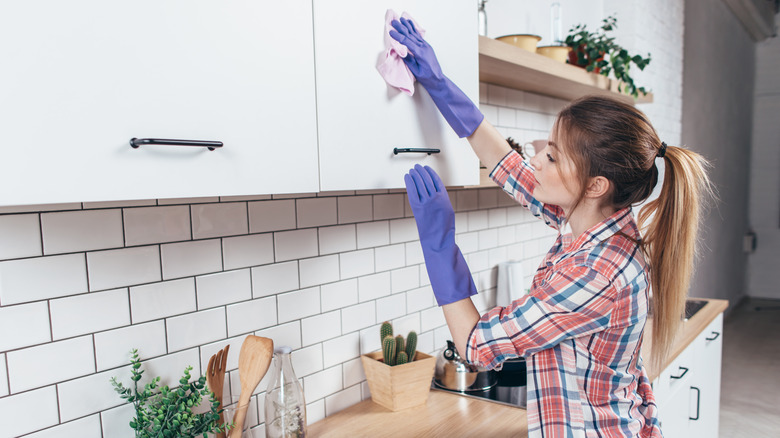 Woman wiping down cabinets