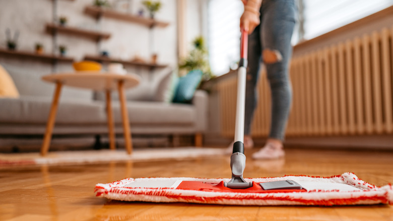 person cleaning hardwood floor