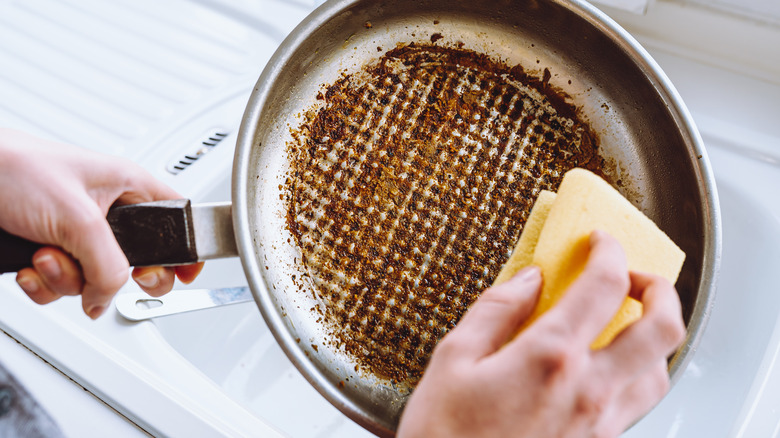 Person scrubbing burnt pan