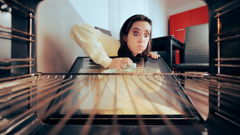 Person cleaning oven door