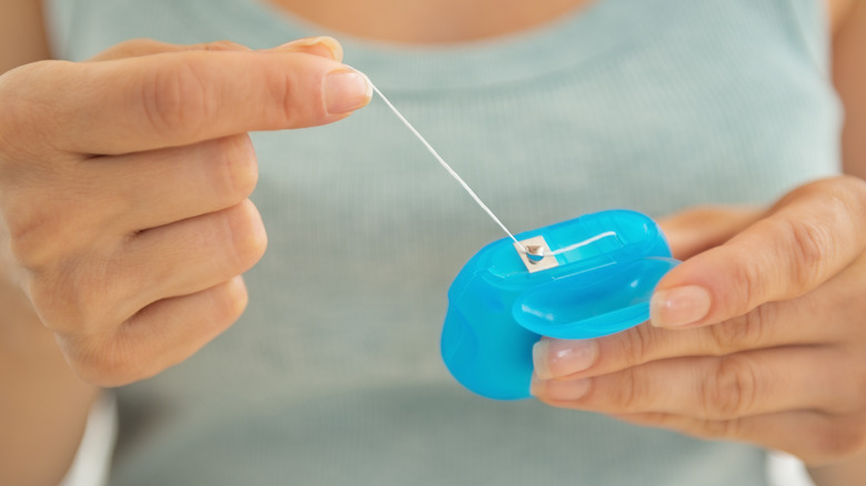 Woman's hands holding dental floss