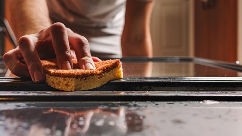 Person cleaning oven door 