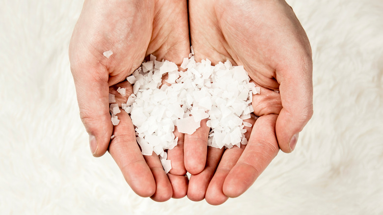 hands holding salt flakes 