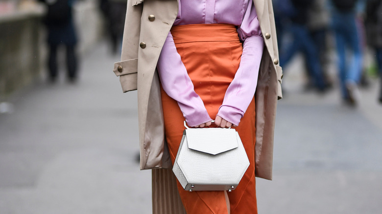 Woman holding a white handbag