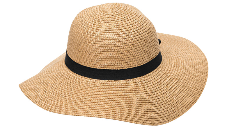 Floppy tan straw hat with black ribbon