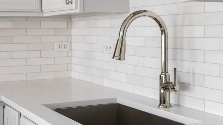 A porcelain countertop in a tiled white kitchen