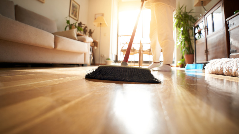 A person sweeping the floor with a broom