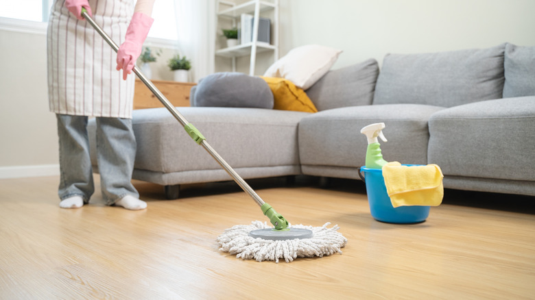 Person cleaning the living room floor with a mop