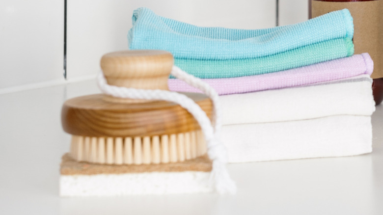 A bamboo brush in front of microfiber towel stack