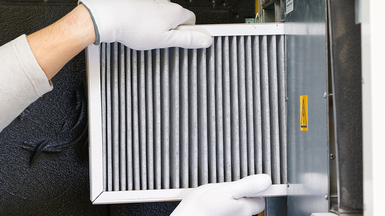 A person changing a furnace filter