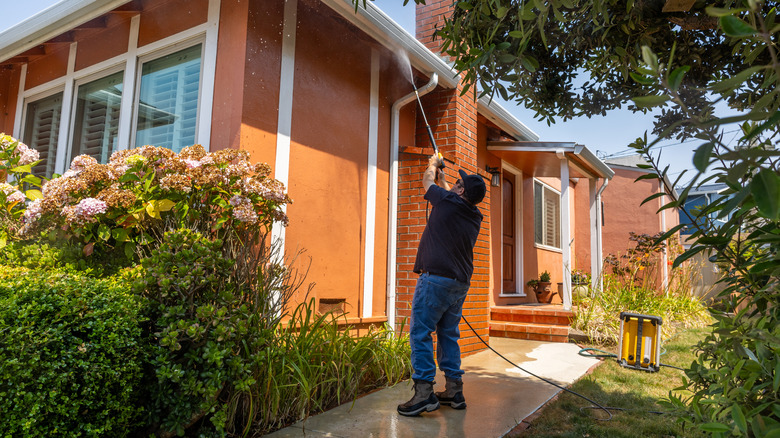 A person power washing a house