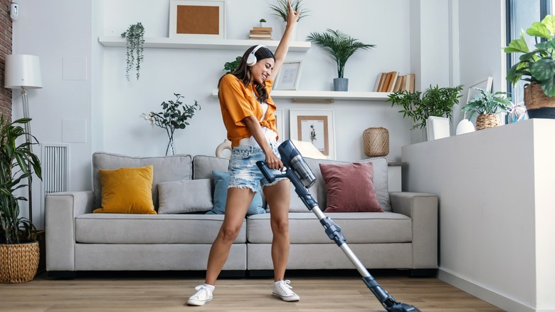 A person listening to music while vacuuming