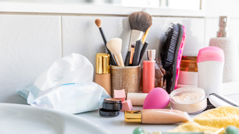 A bathroom sink is cluttered with toiletries.