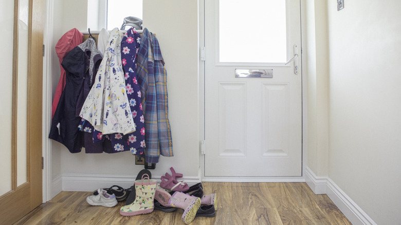 A messy entryway with coats and shoes