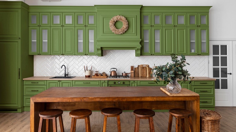 Green kitchen with crown molding attached to upper cabinets