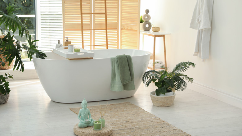 bright spa-like bathroom with tub and plants