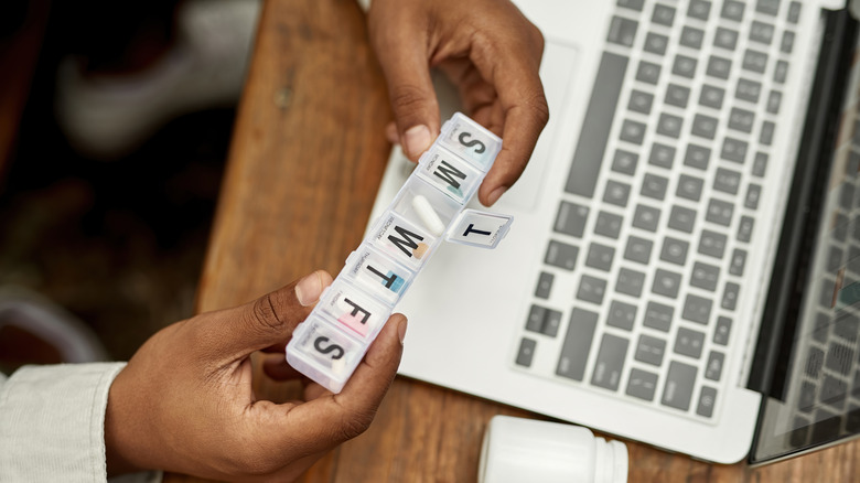 person with pill organizer in hand 